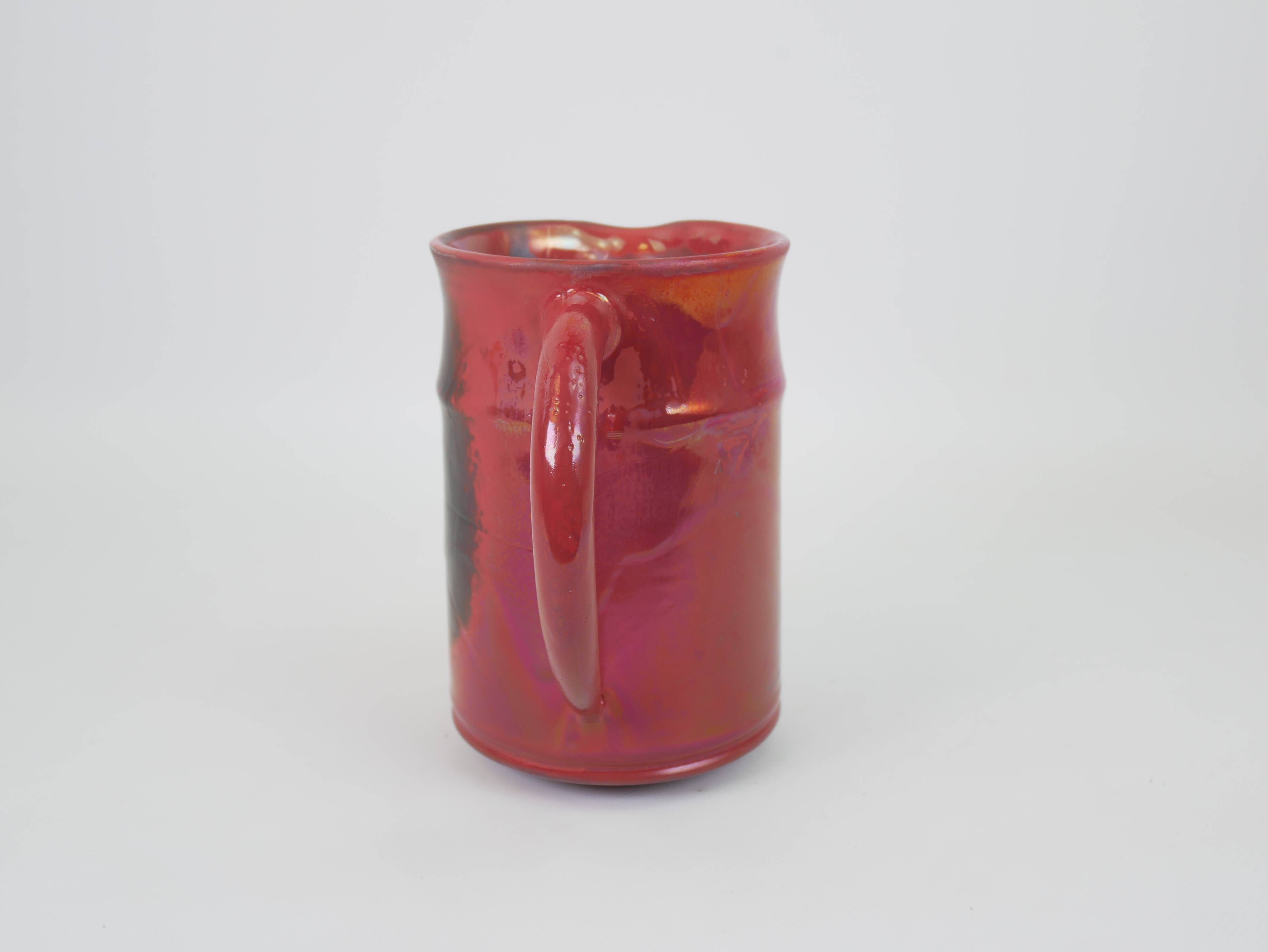 Red glazed ceramic jug with relief