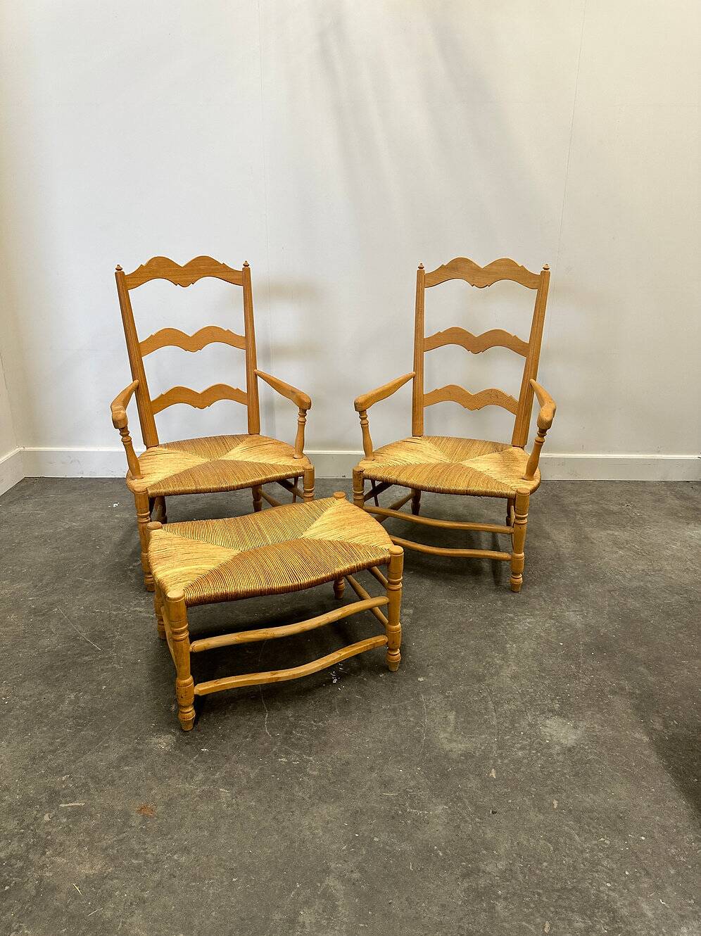 Pair of French Provencal Radassier beech chairs and ottoman, with rush seating.