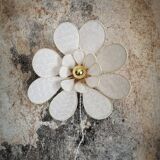 Applique murale fleur composée de pétales en rotin et broderie anglaise