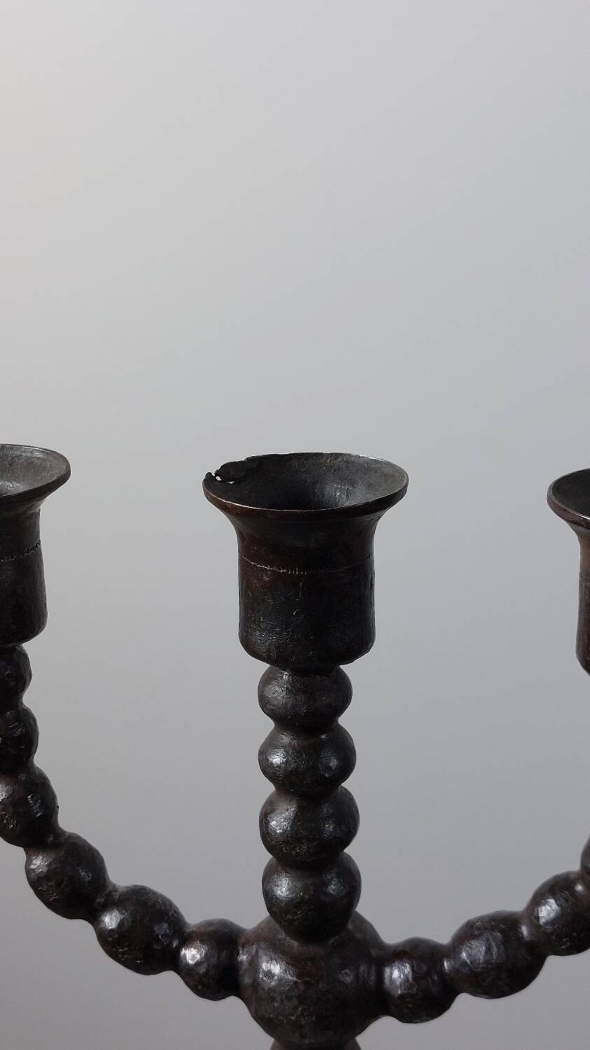 Candelabrum in the shape of a spool, skilfully forged in menorah style.