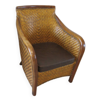 Colonial style armchair in woven rattan and exotic wood