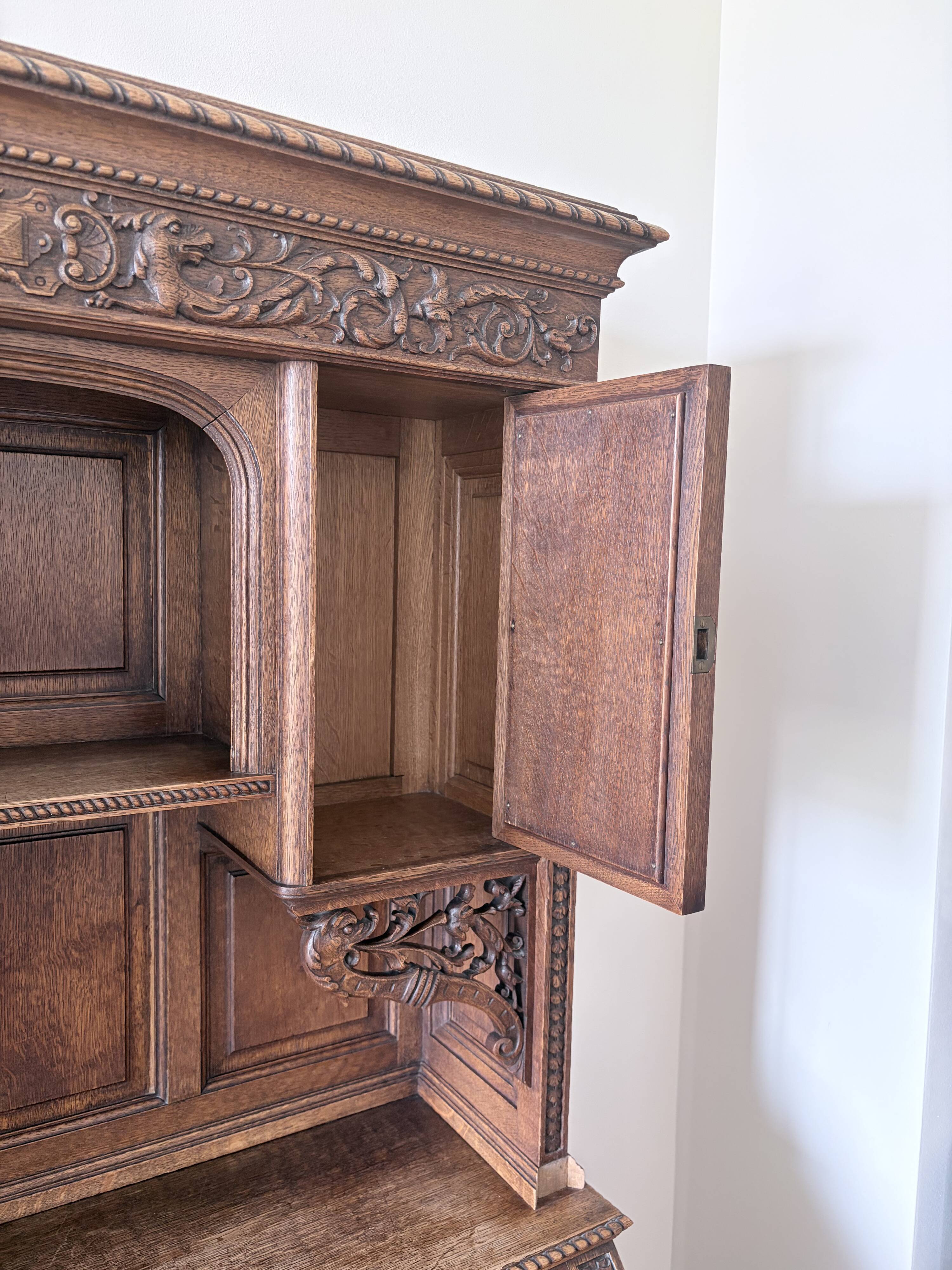 Large secretary with a drop-down front in carved oak, neo-Renaissance style.
