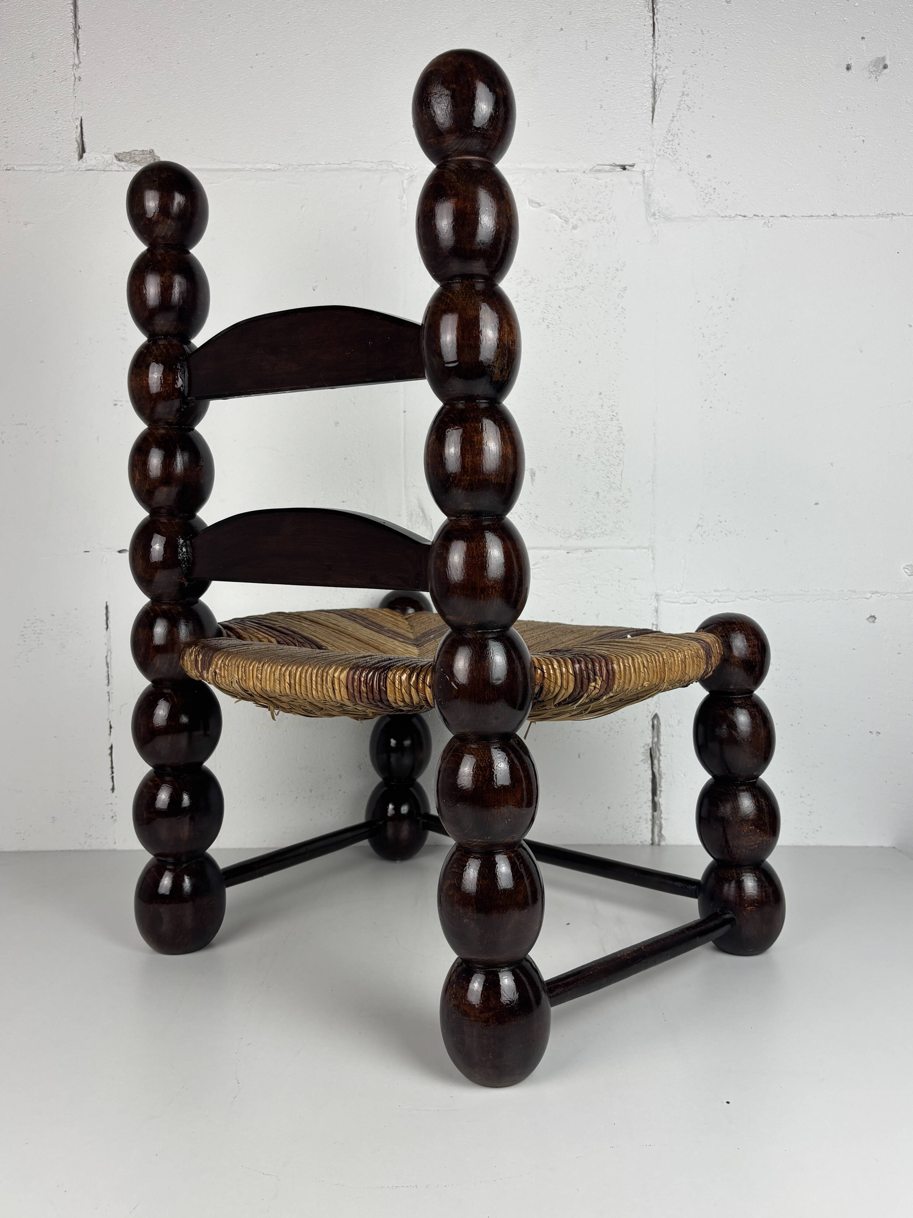 Brutalist wood turned bobbin low rush chair n the style of Charles Dudouyt