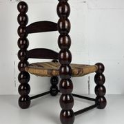 Brutalist wood turned bobbin low rush chair n the style of Charles Dudouyt