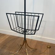 Designer floor lamp in black lacquered metal and brass, incorporating a magazine rack