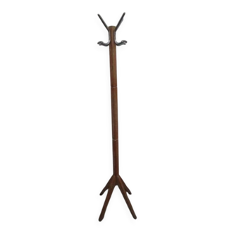 Antique light wood coat rack with splayed legs.