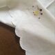 Oval tablecloth and napkins in white cotton embroidered in color
