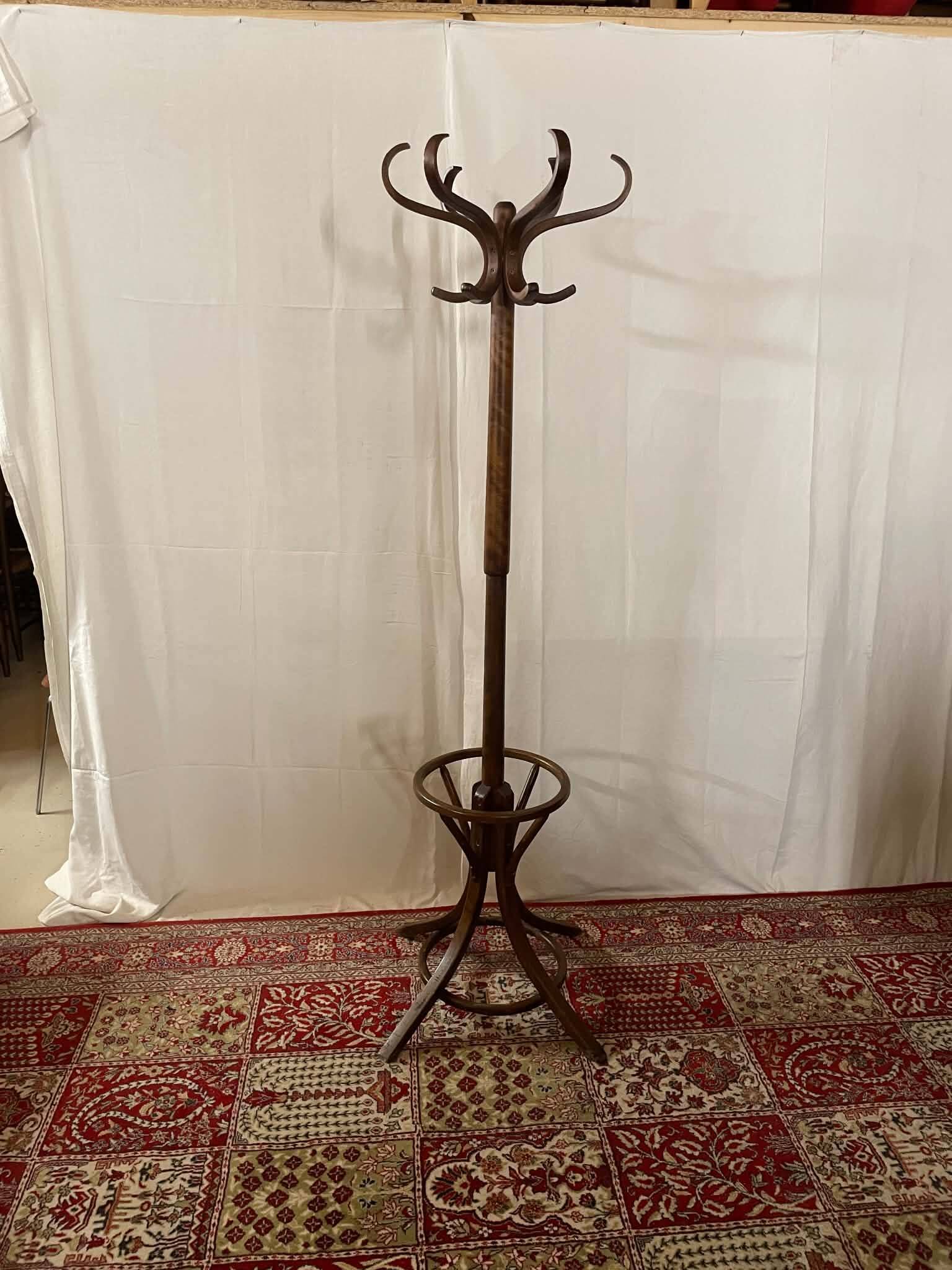Antique curved wooden coat rack with umbrella stand.