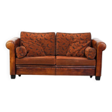 Canapé en cuir de mouton 2,5 places, luxueux et confortable, avec des coussins en tissu.
