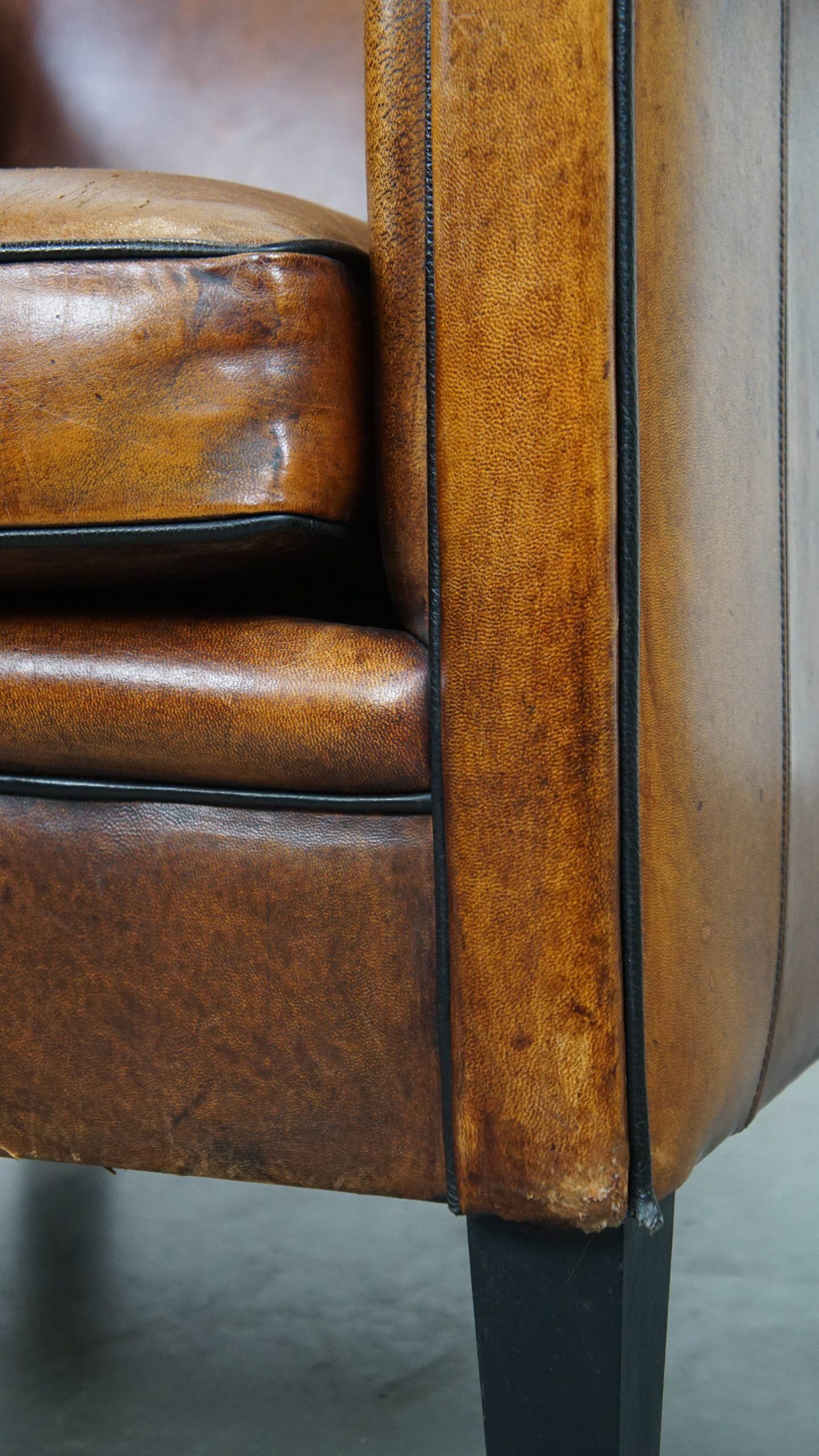 Sheepskin Art Deco design armchair with sleek finish and black piping