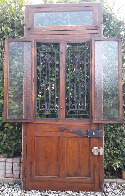 Oak entrance door and its frame and transom, wrought iron gates