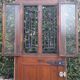 Oak entrance door and its frame and transom, wrought iron gates