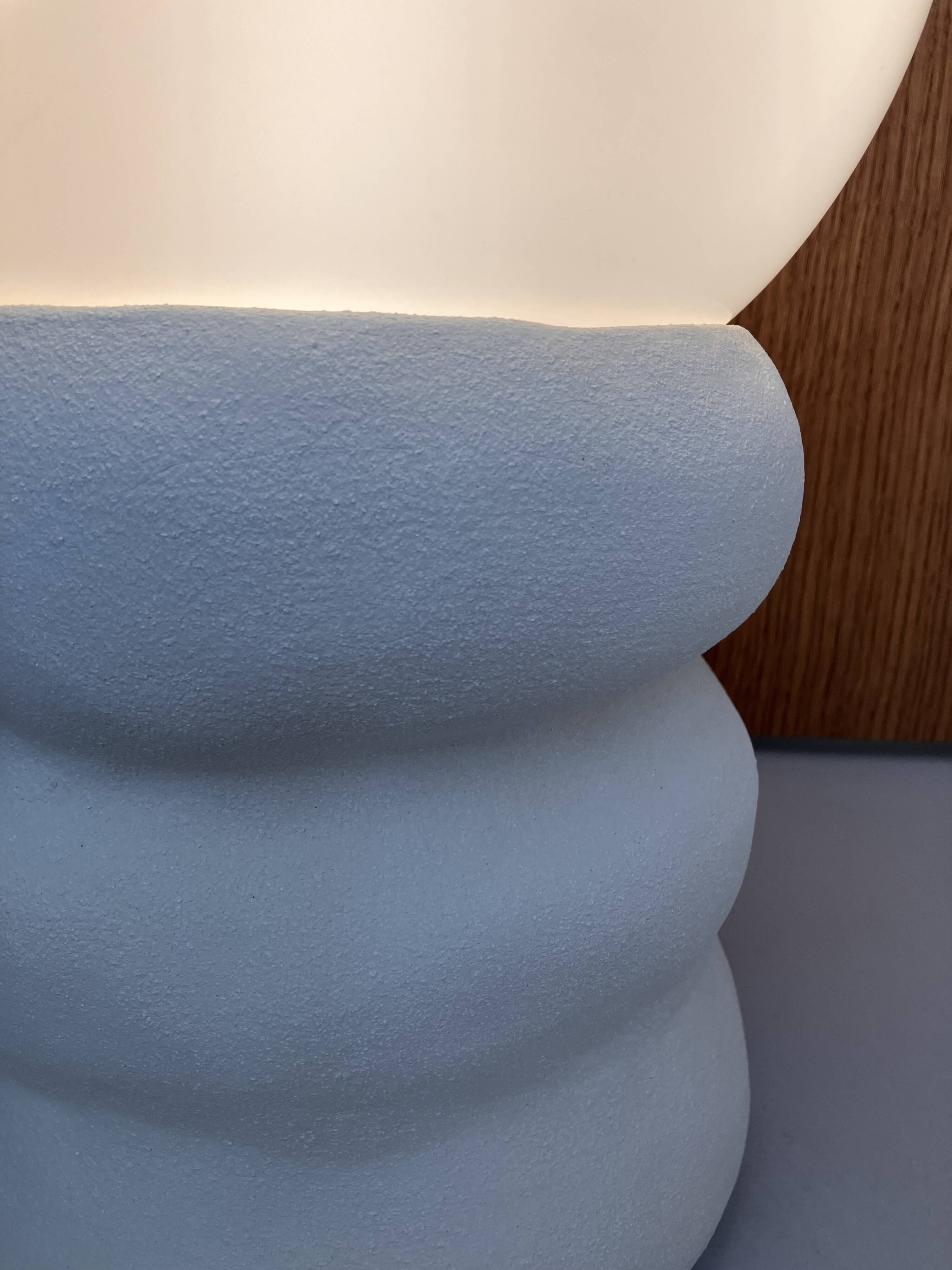 Large table lamp in off-white ceramic with an organic globe shape.