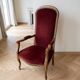 Louis XV style Voltaire armchair in wood and burgundy fabric.