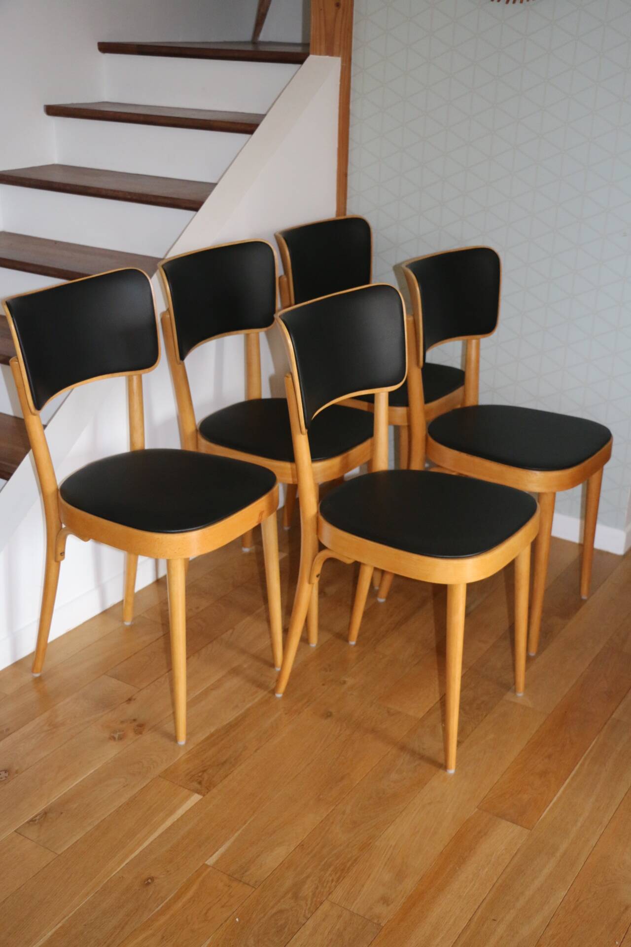 5 baumann chairs with large backs in black faux leather.