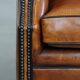 Sheepskin wingback armchair with stitching and black piping