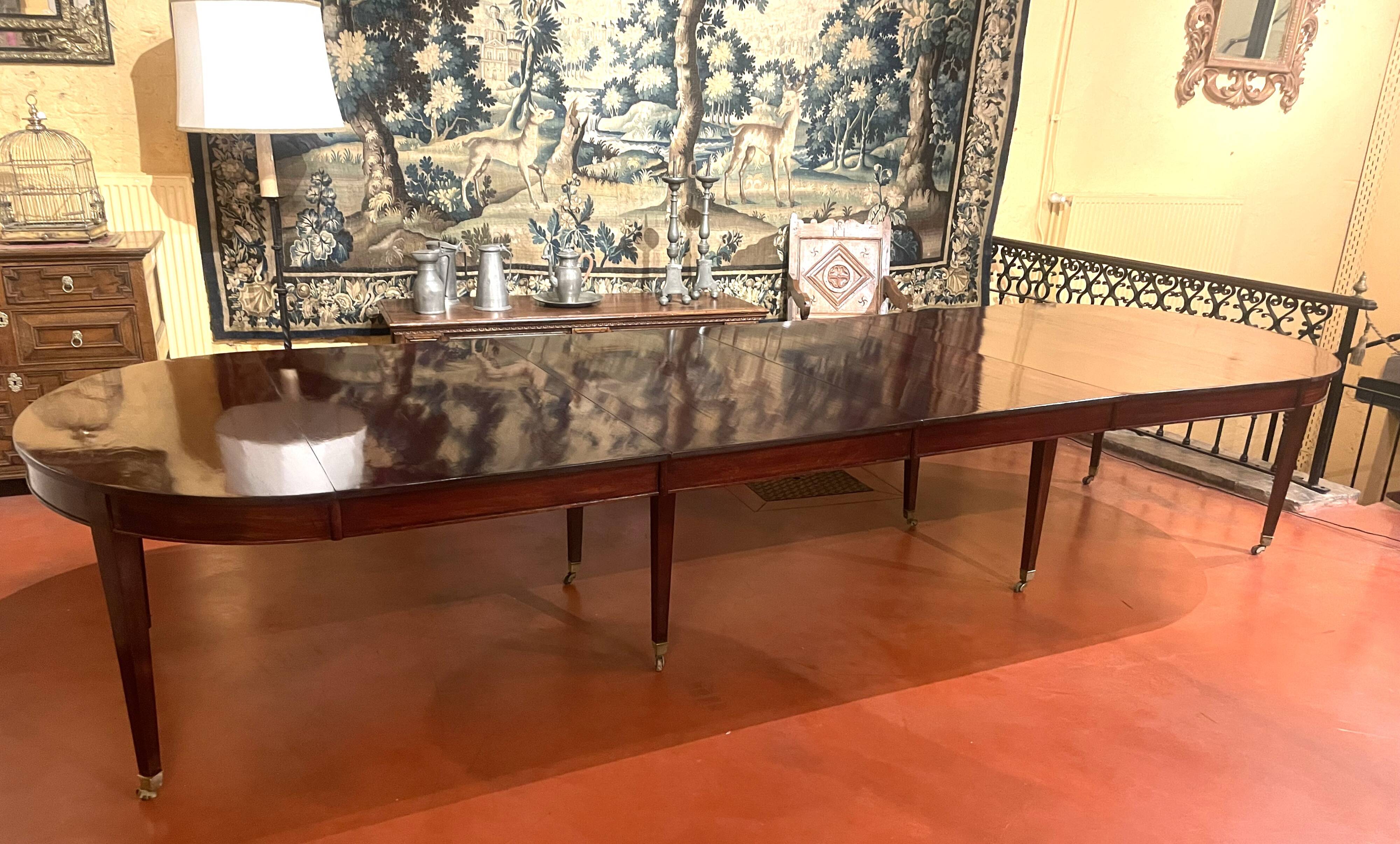 Directoire period extendable dining table in mahogany with a band.