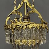 Antique chandelier in gilded bronze with crystal pendants.