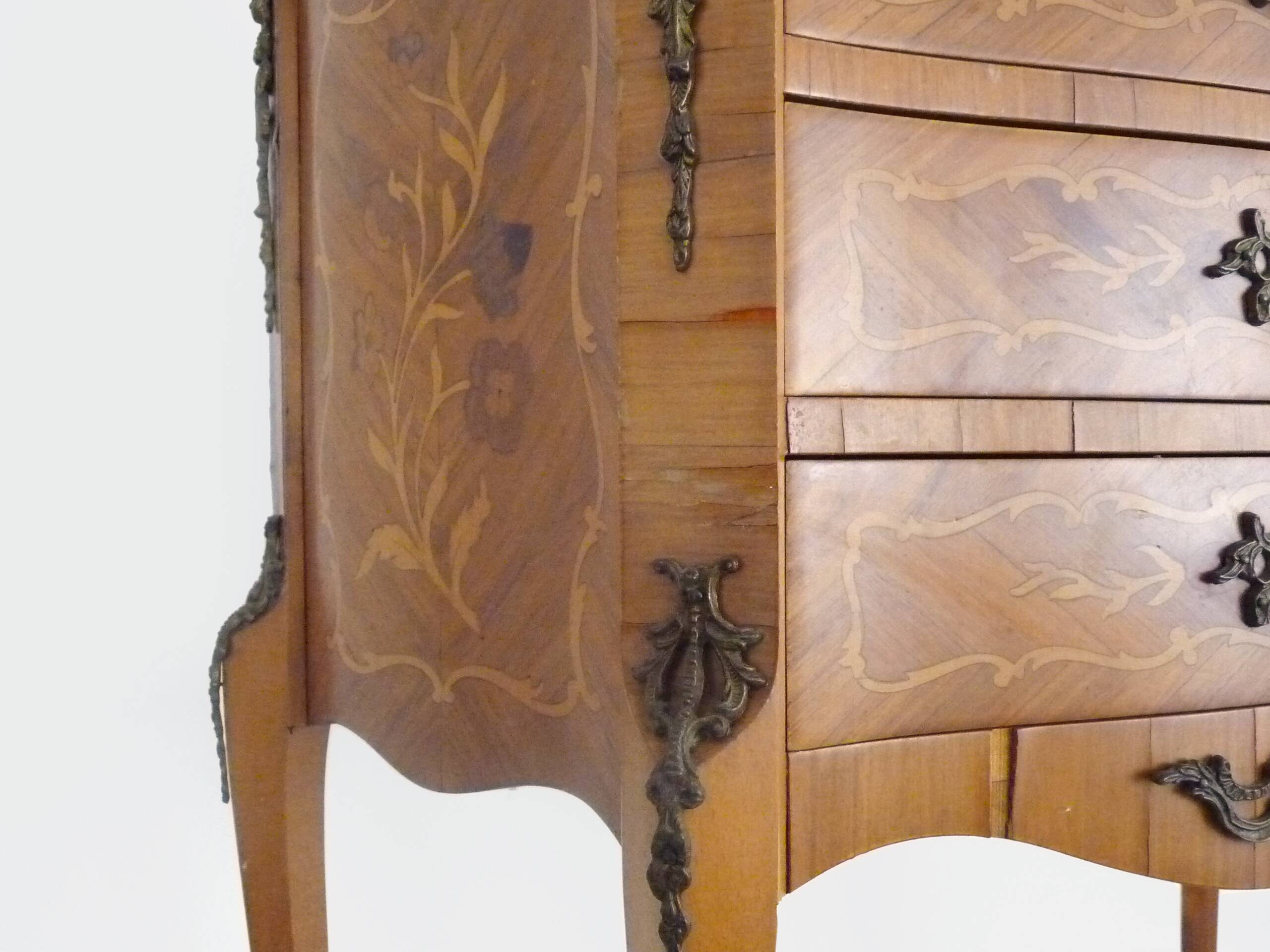 Baroque style wooden chest of drawers with bronze frieze.
