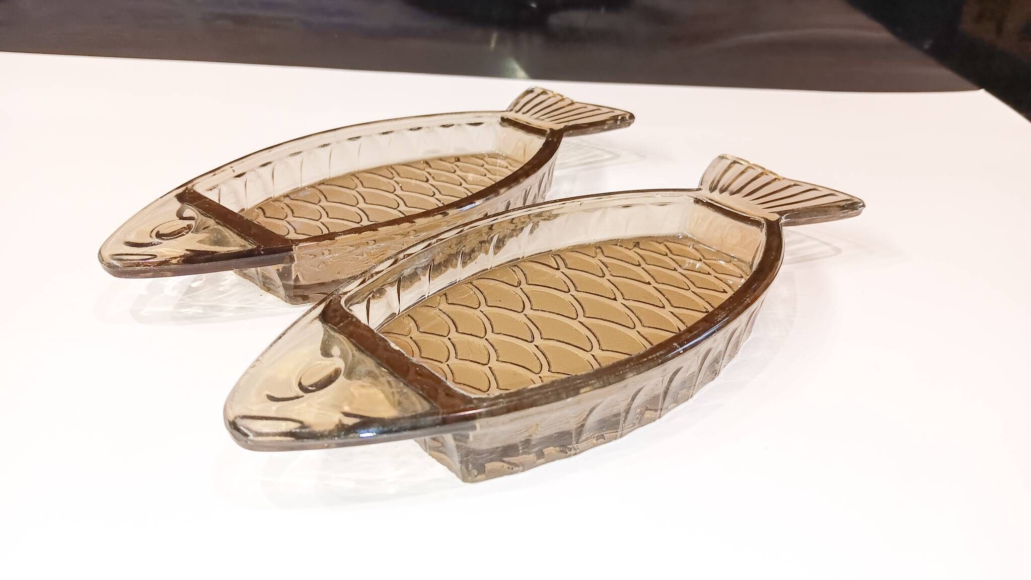Set of 2 transparent smoked glass bowls in the shape of a fish.