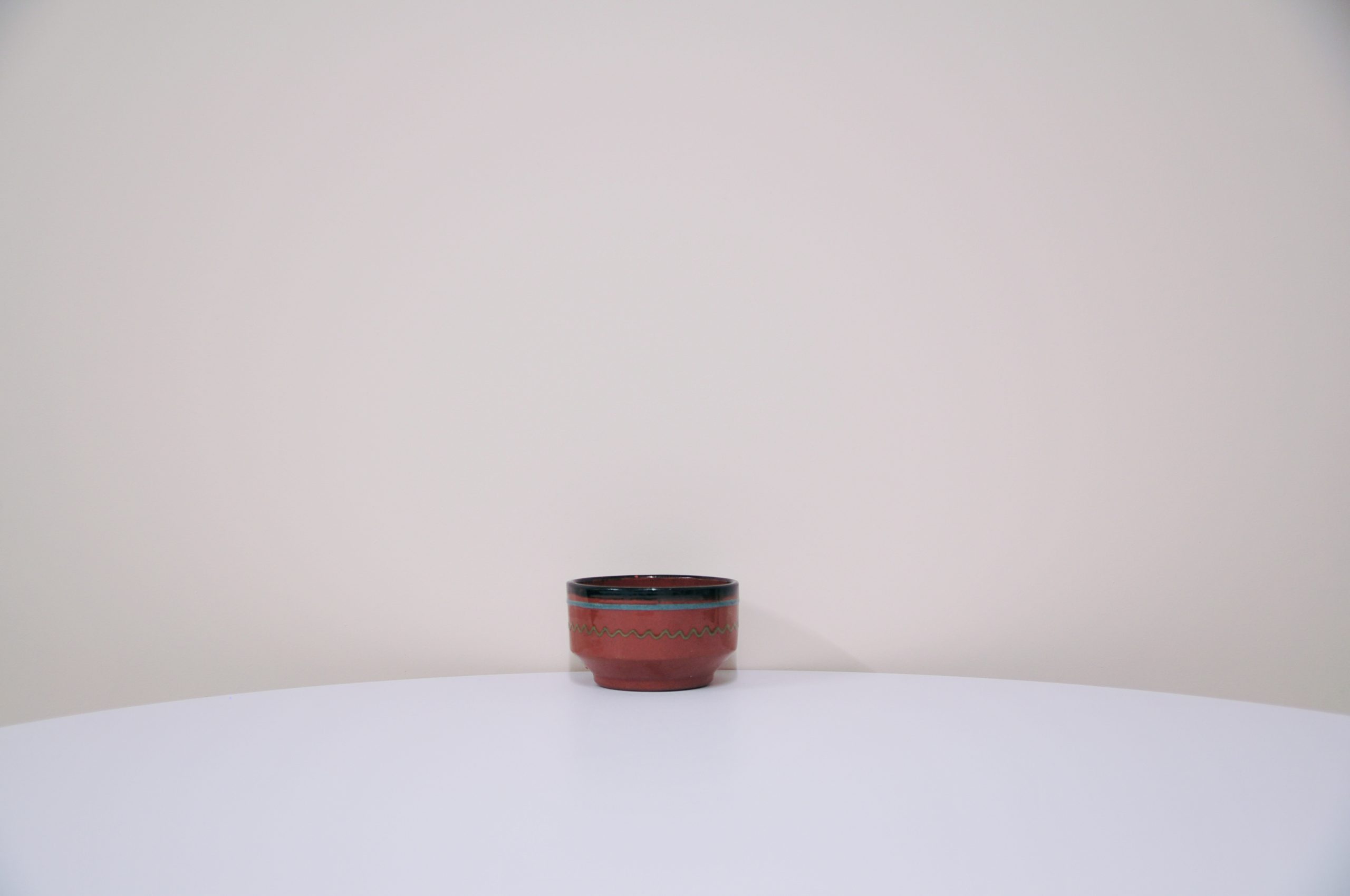 Brown bowl with a green and blue design