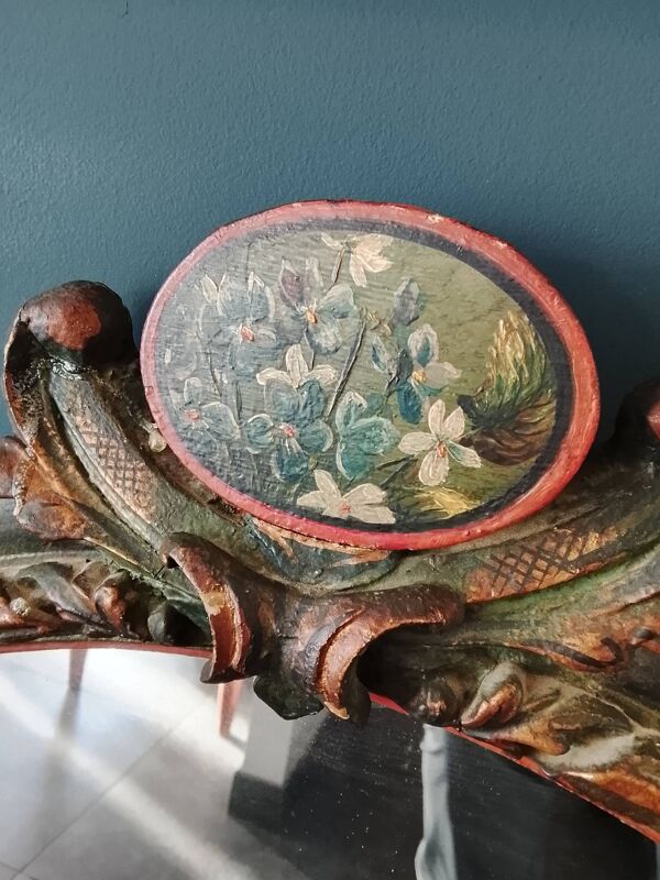 Miroir ovale ancien dans un cadre sculpté et peint avec un panneau floral