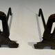 Pair of Modernist Andirons in Cast Iron with Openwork Uprights and Tripod Bases