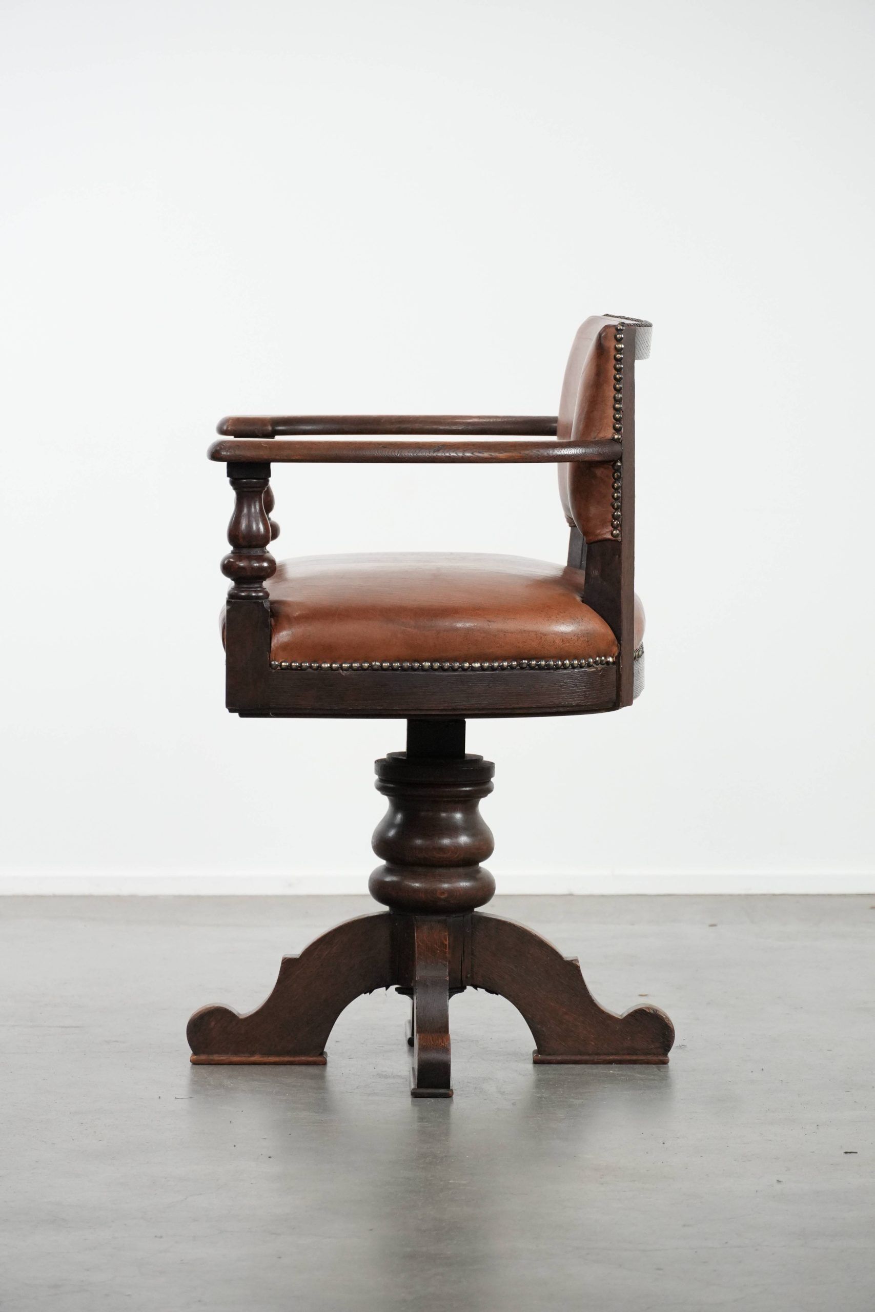 Elegant antique sheepskin leather desk chair with a heavy wooden frame