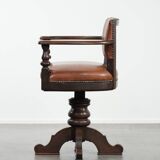 Elegant antique sheepskin leather desk chair with a heavy wooden frame