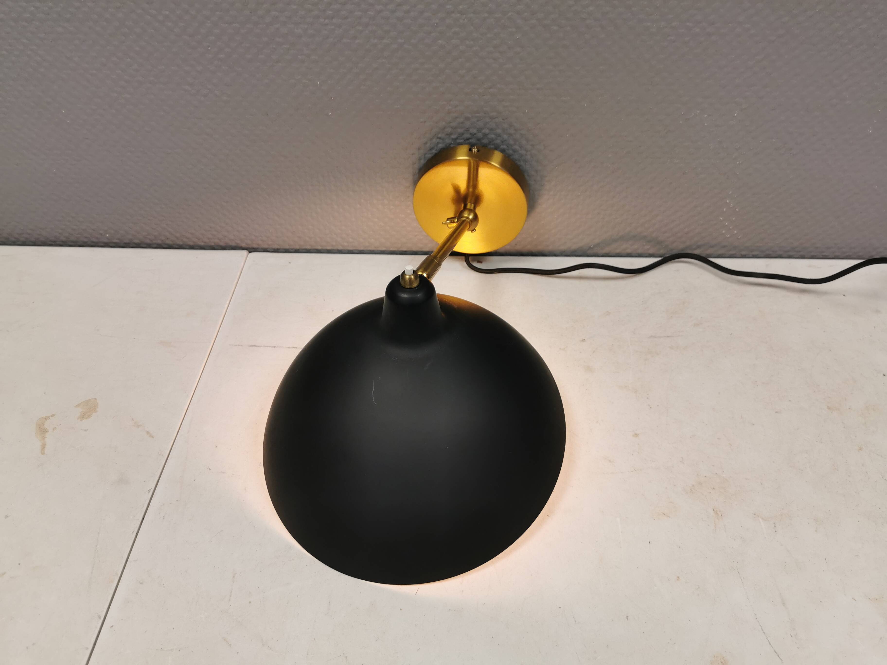 A wall lamp in black and brass-coloured finishes. Danish, early 2000s.