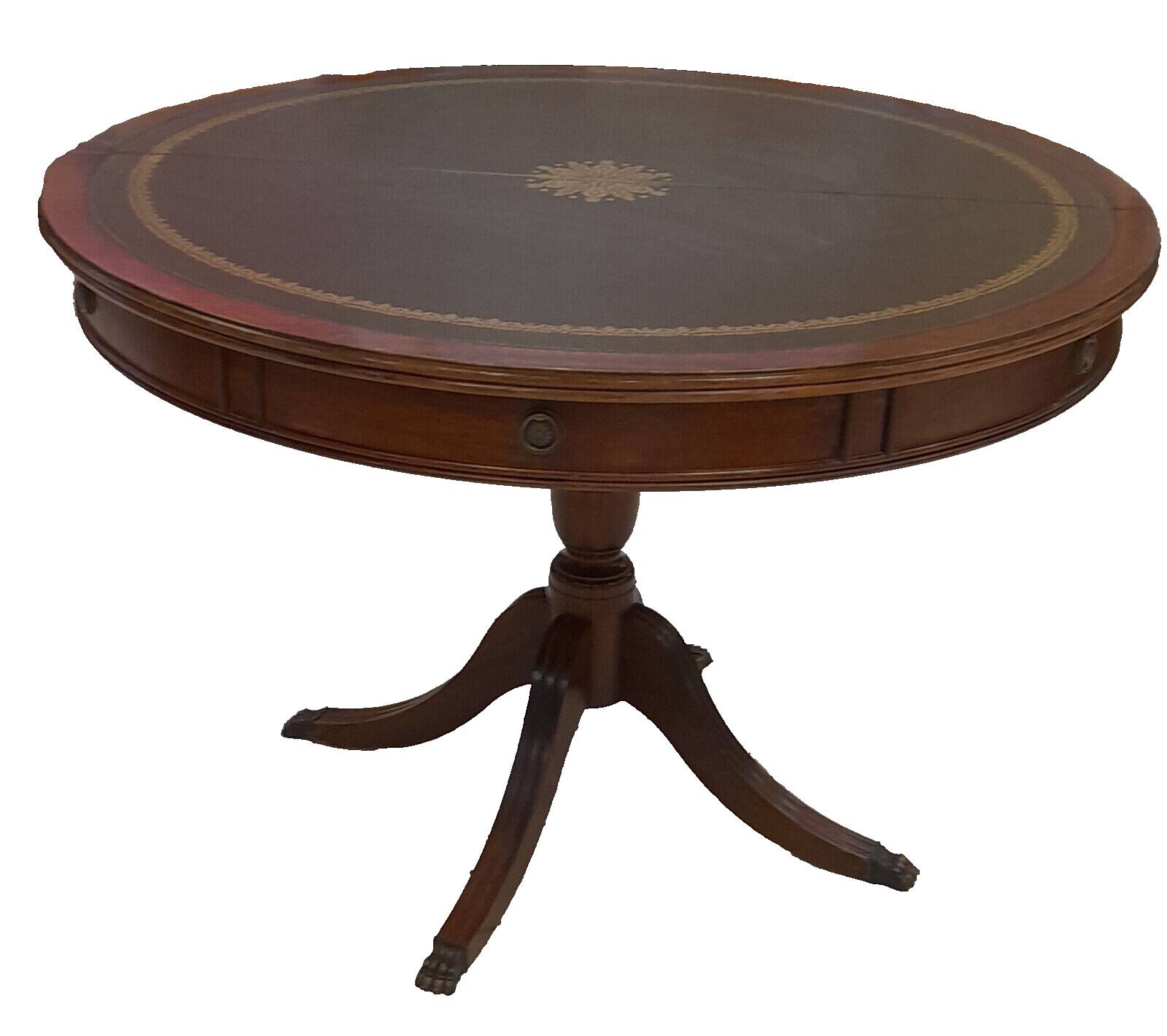 English style round table with green and gold leather top, quadripod with brass claws