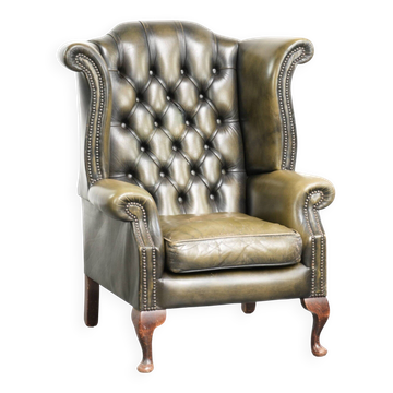 Fauteuil à oreilles Chesterfield en cuir vert au style anglais, plein de caractère.