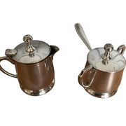Two small silver-plated metal tea service pots from the 20th century.