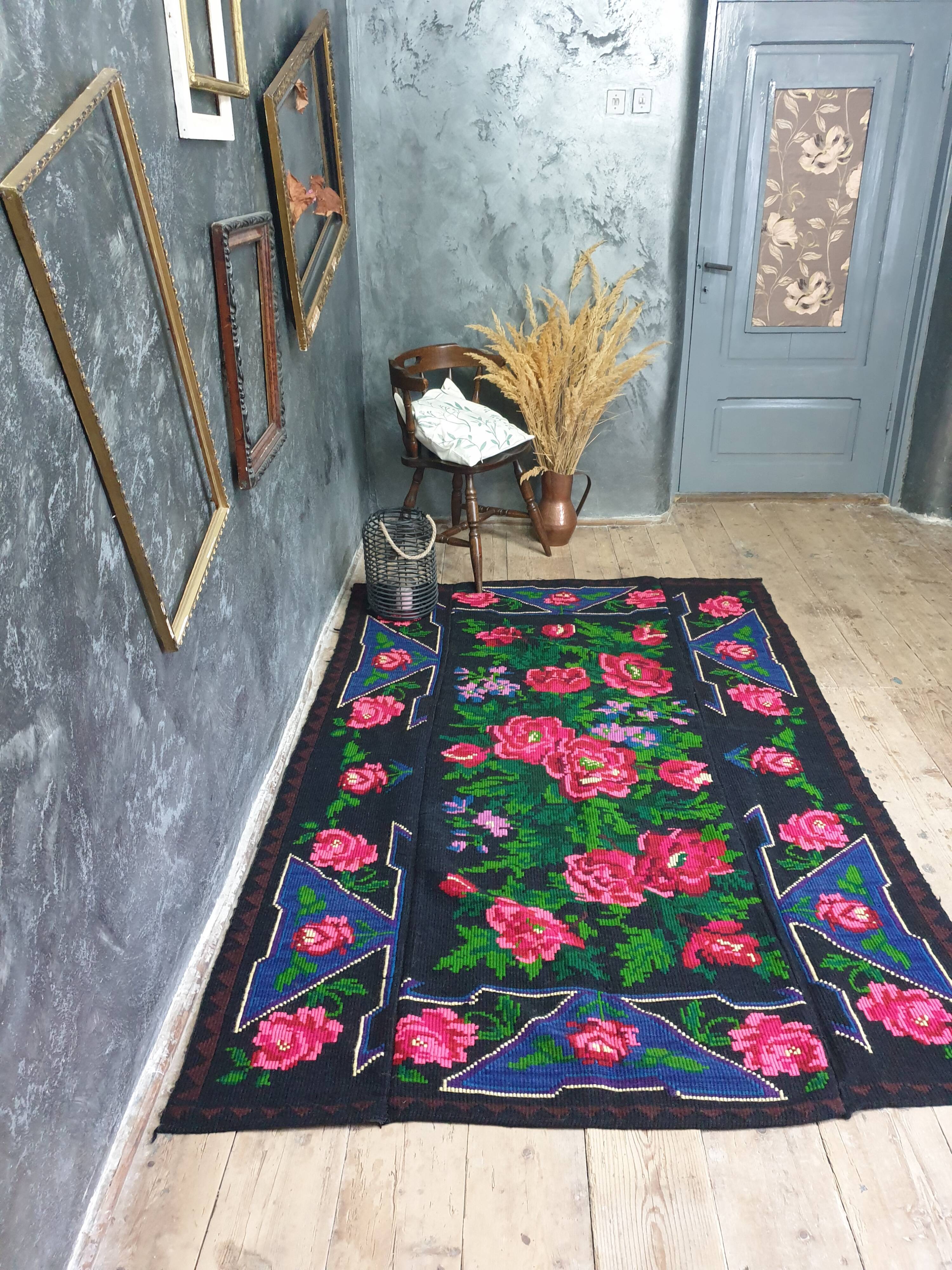 Handwoven floral wool rug, black background with pink roses