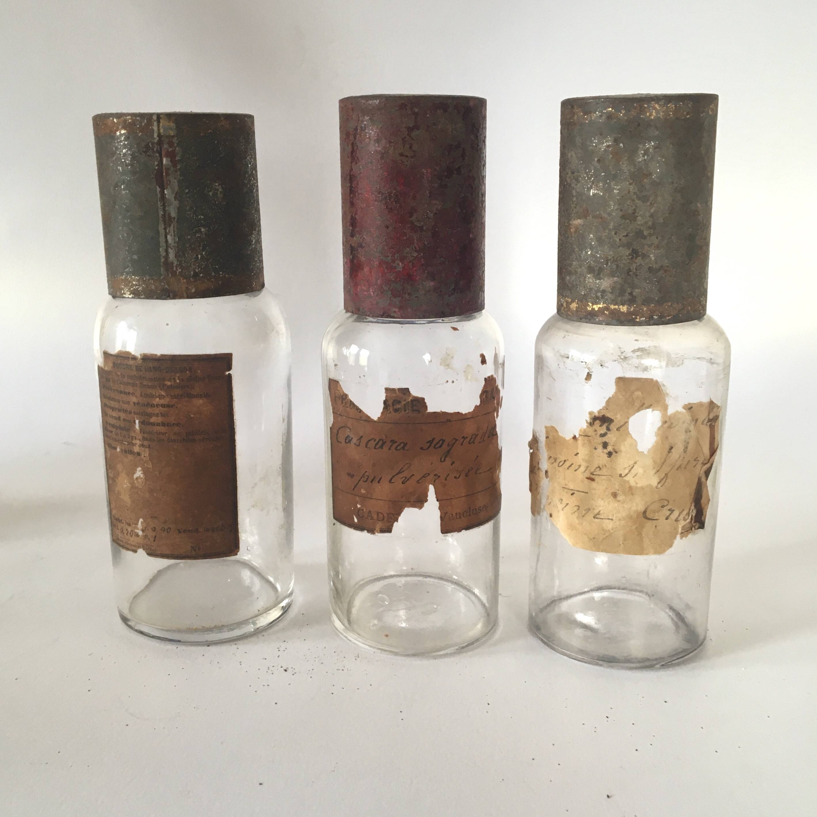 Trio apothecary bottles, painted metal caps