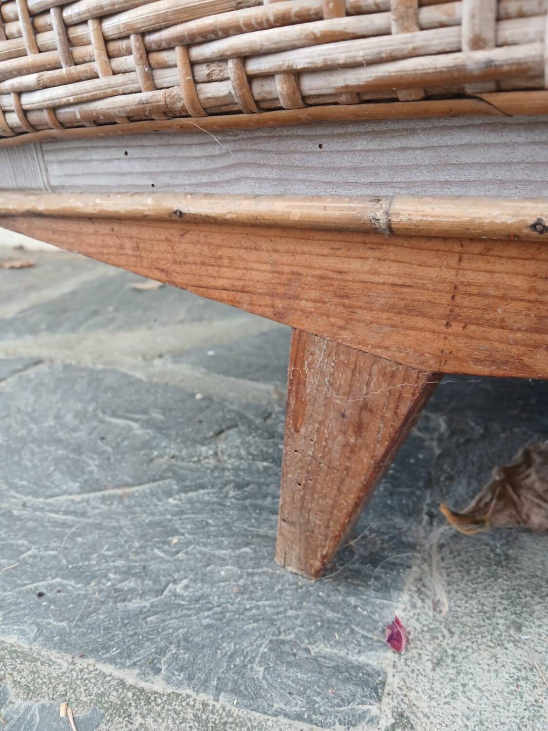 Vintage woven rattan furniture with tapered legs.