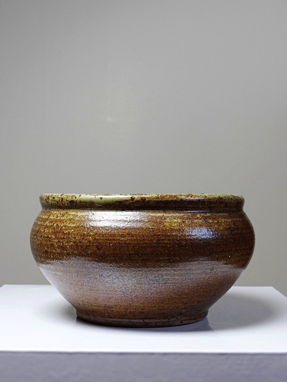 Vintage glazed stoneware bowl or planter in rustic wabi-sabi style.