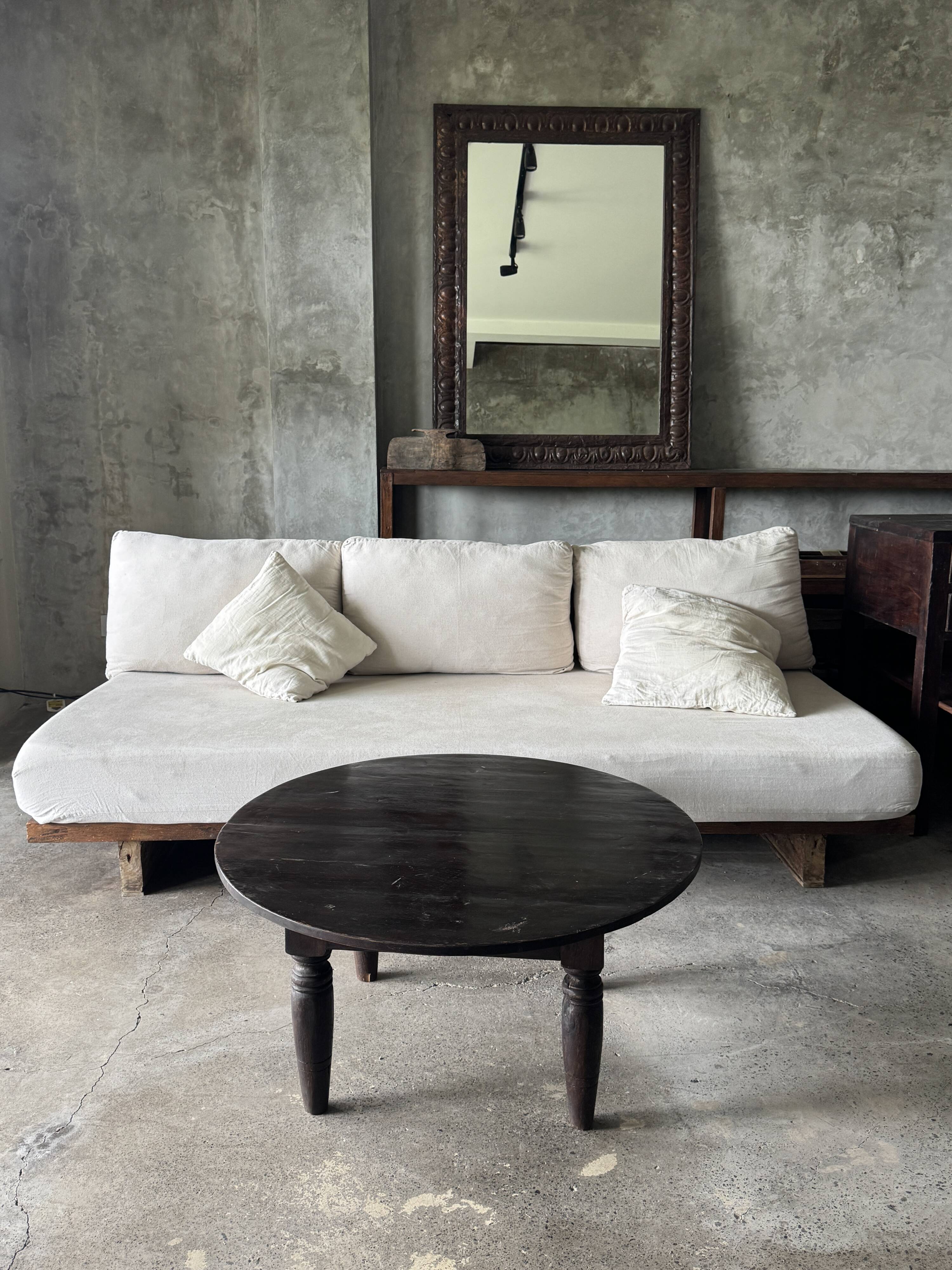 Antique round coffee table in Indonesian teak with turned legs.