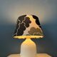Small Space Age table lamp with a porcelain base and black and white flower shade.