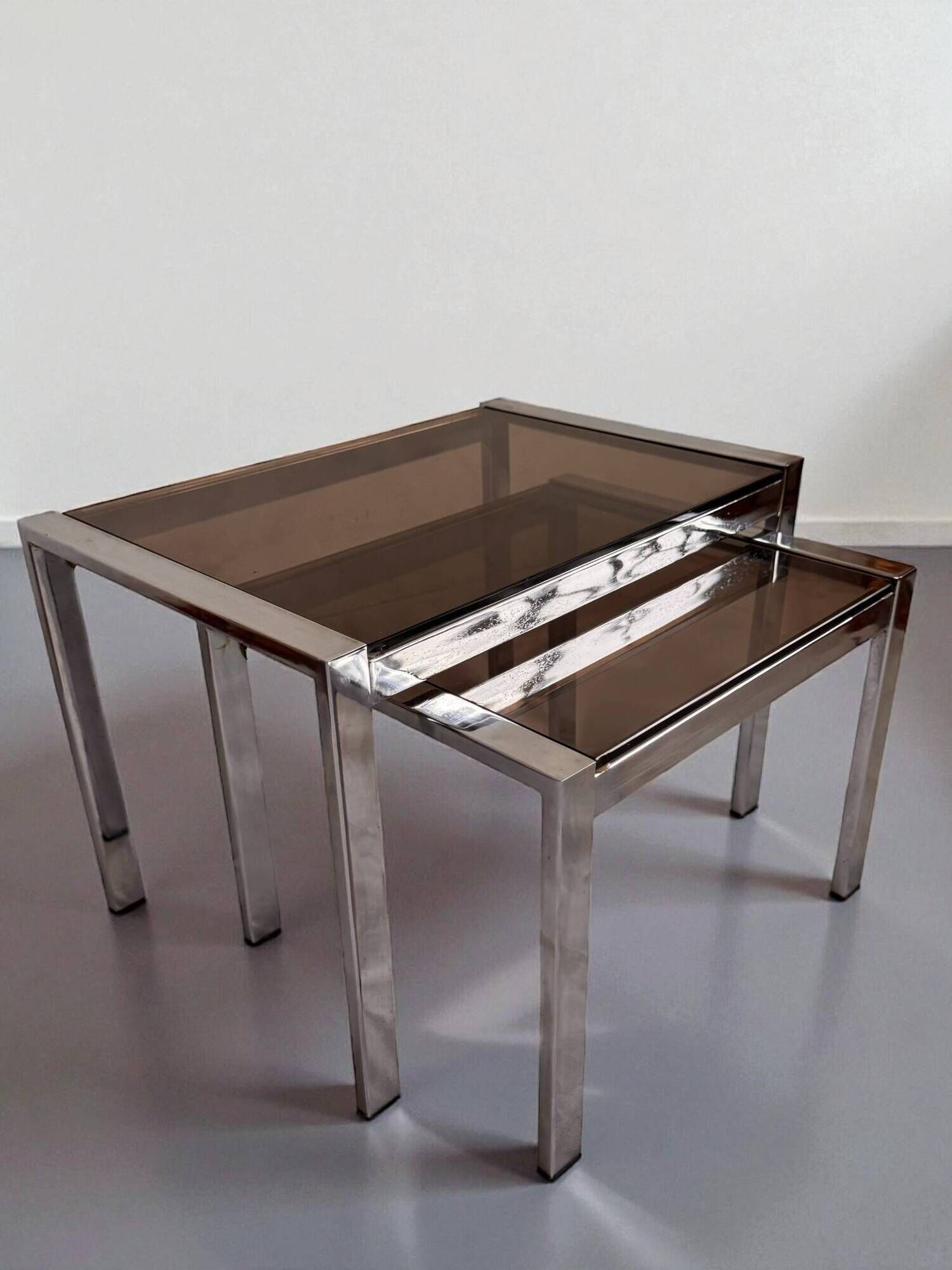 Vintage nesting tables from the 1970s, chrome and smoked glass, mid-century modern.