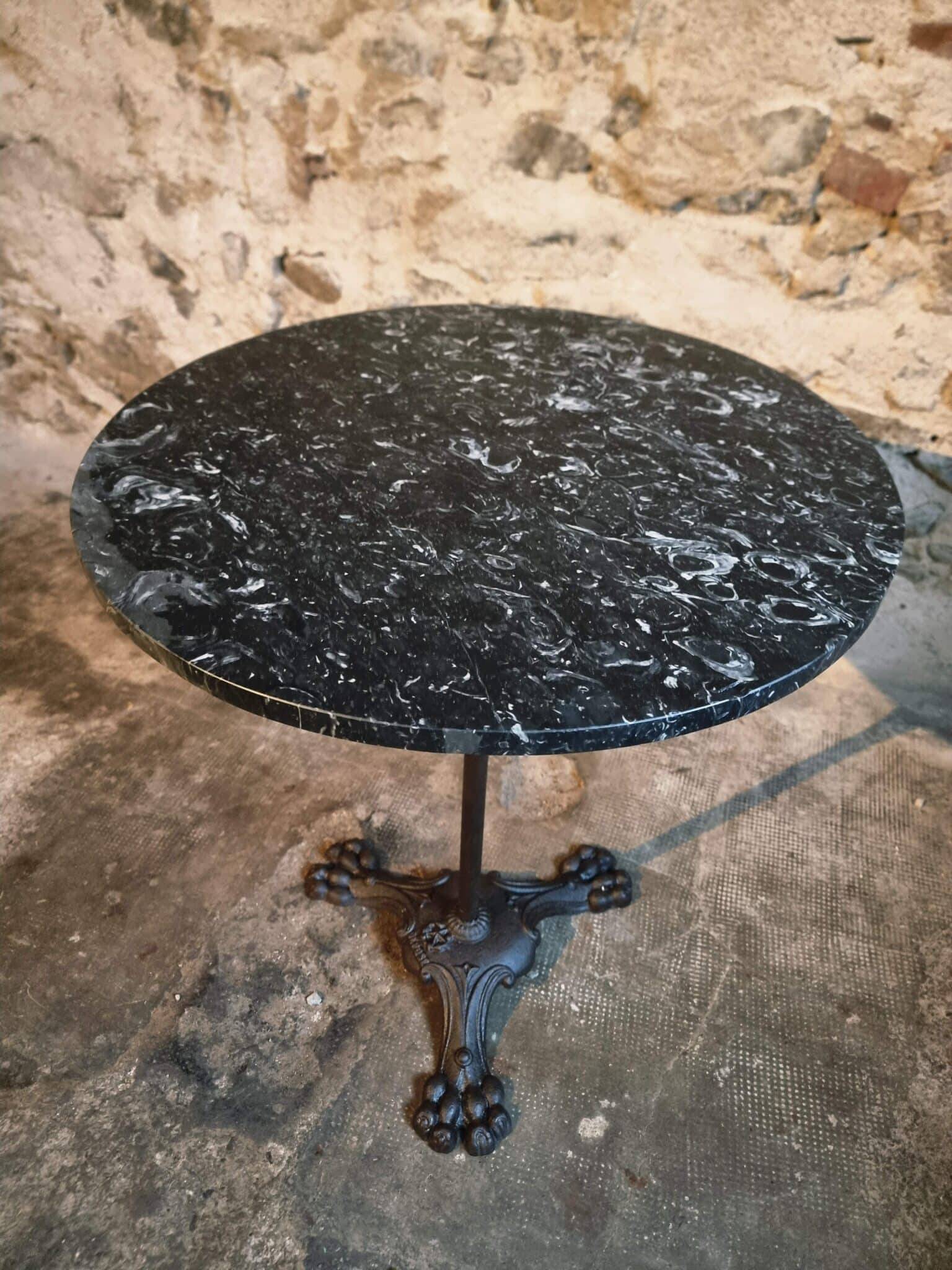 Old French bistro table with a marble top and a cast iron base.