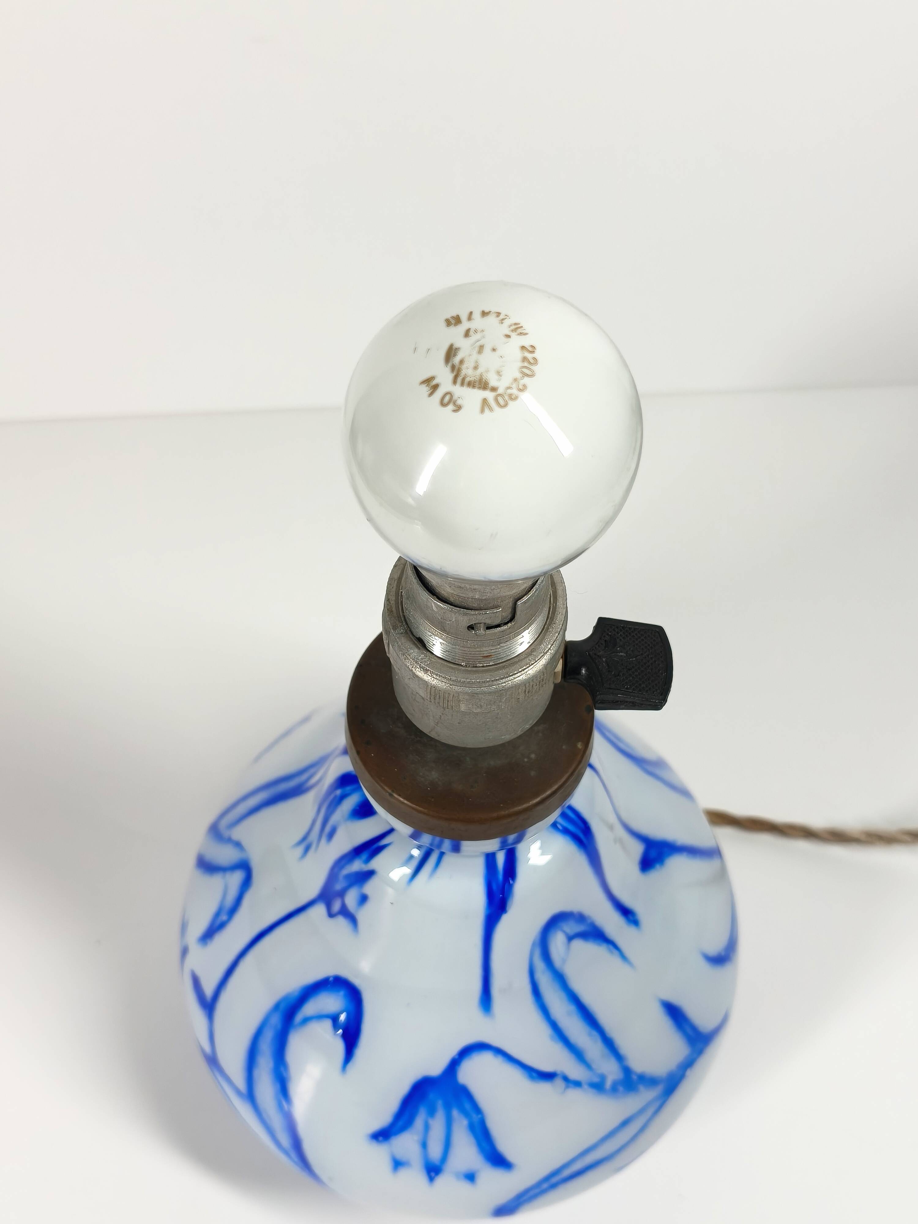 Antique table lamp in opaline glass with blue floral decoration.