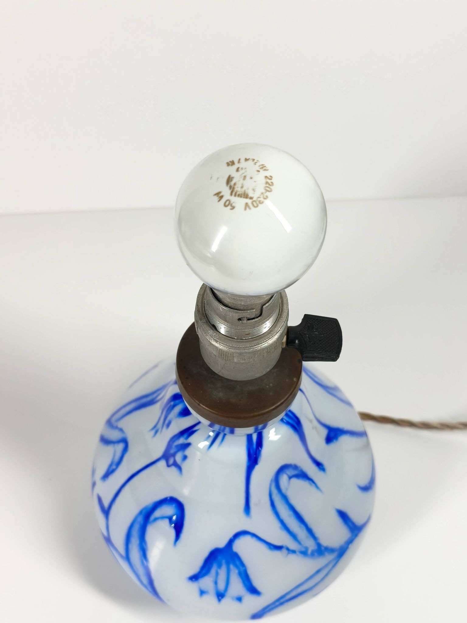 Antique table lamp in opaline glass with blue floral decoration.