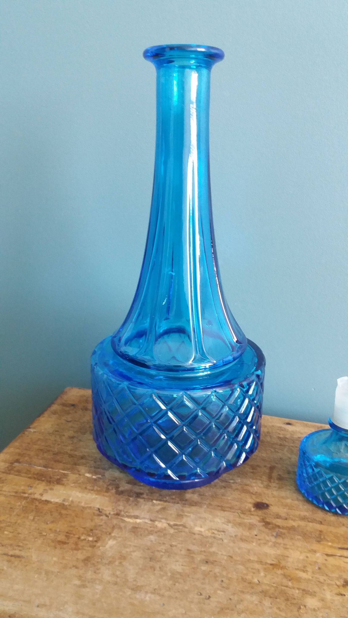 Turquoise glass carafe bottle with a stopper.