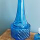 Turquoise glass carafe bottle with a stopper.
