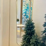 Contemporary rectangular mirror with rounded edges and brass frame.