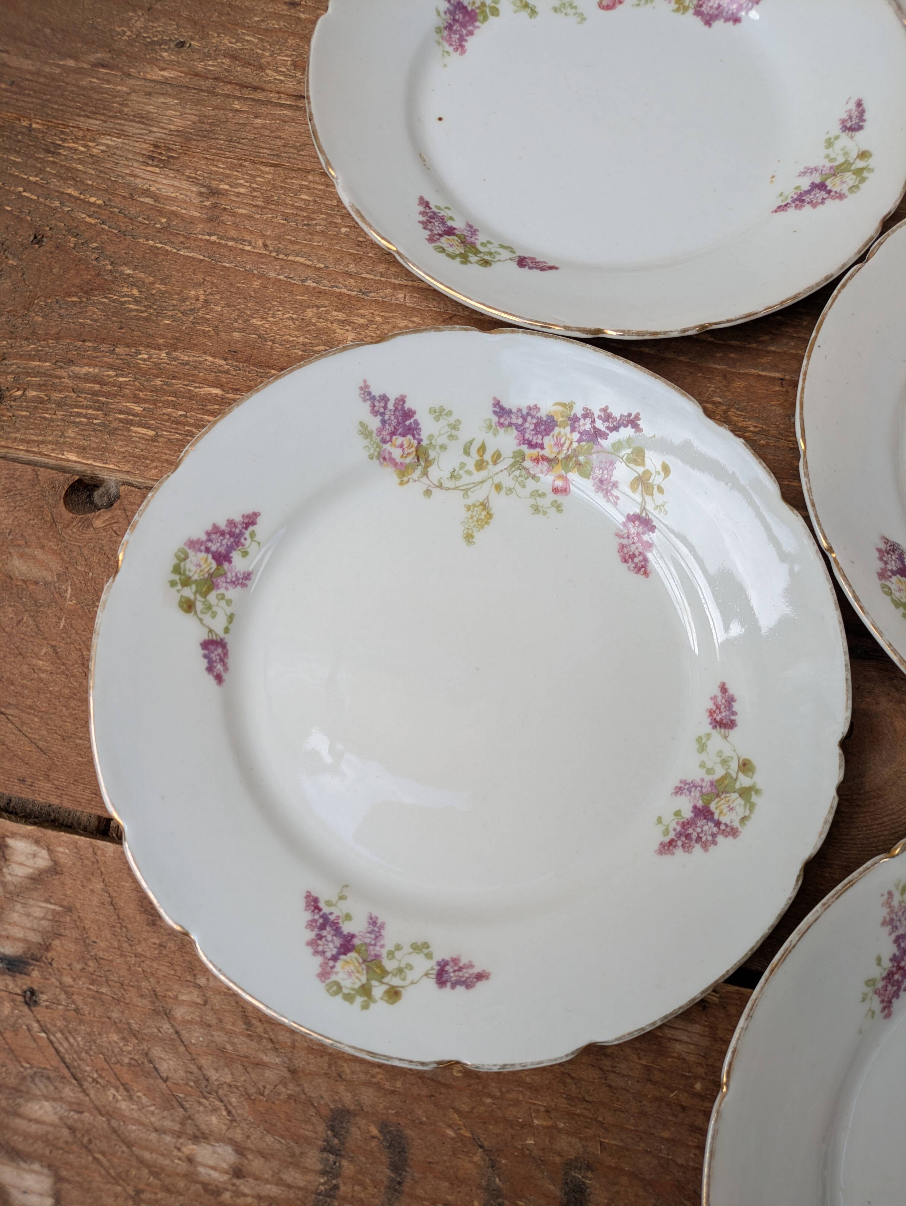 7 dessert plates in porcelain with a violet lilac design and a gold rim.