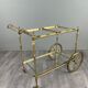Rolling table cart in gilded brass with two glass shelves, 20th century.
