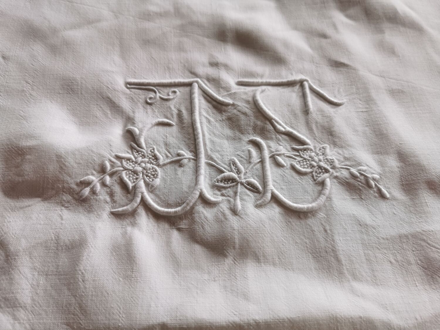 Antique embroidered linen sheet with a monogram.