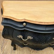 Commode galbée peinte en noir et bois
